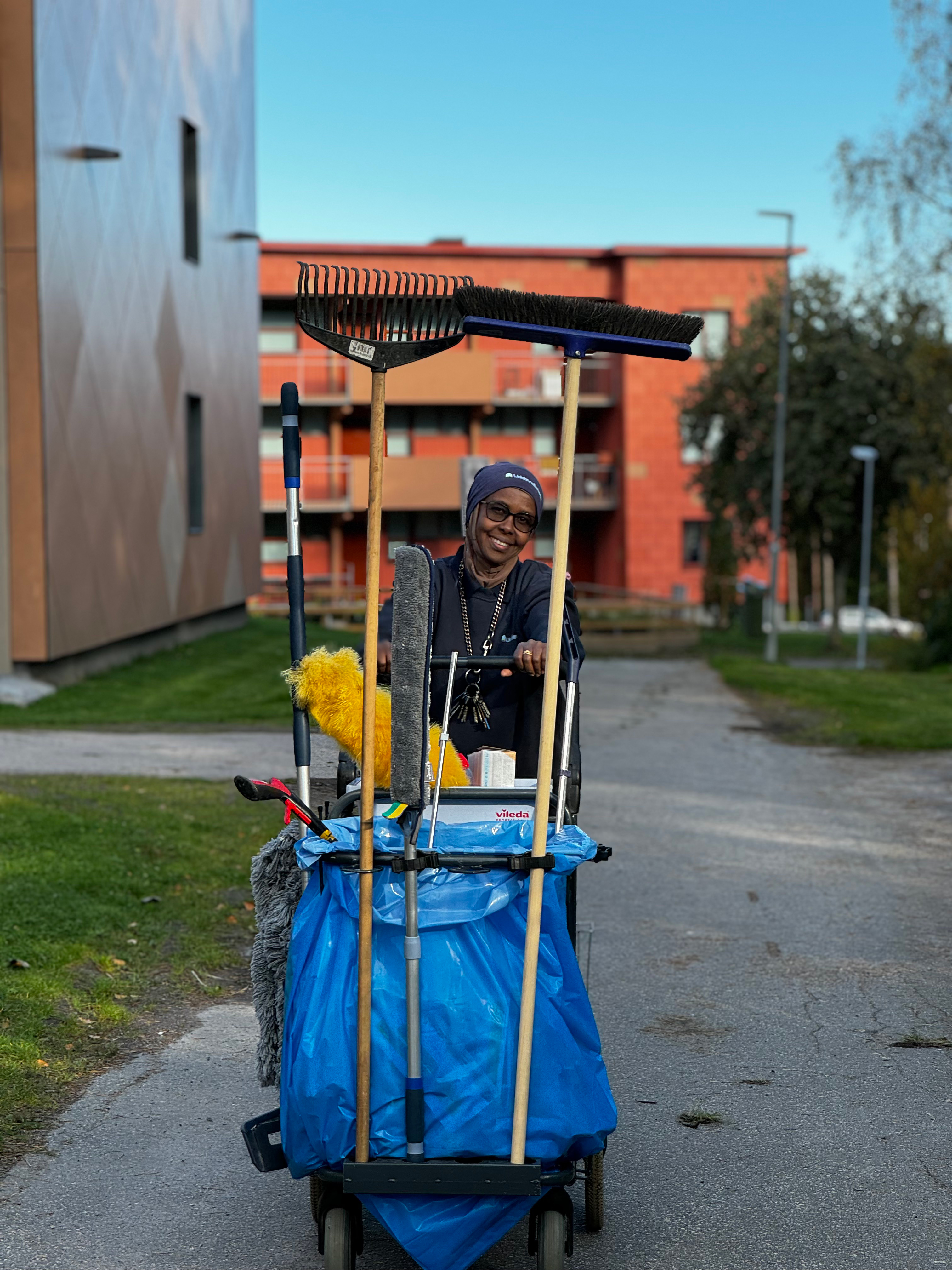 Lokalvårdare som går med sin städvagn